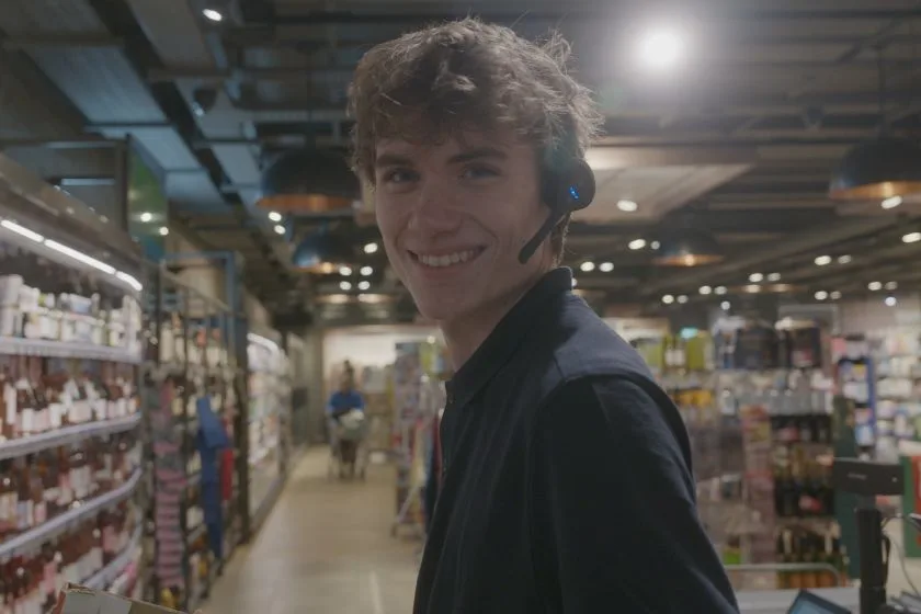 Smiling associate with a Pro12 headset in a grocery aisle