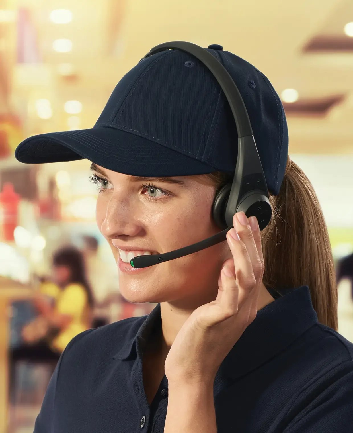 Smiling associate in a cap wearing a Quail headset on the shop floor