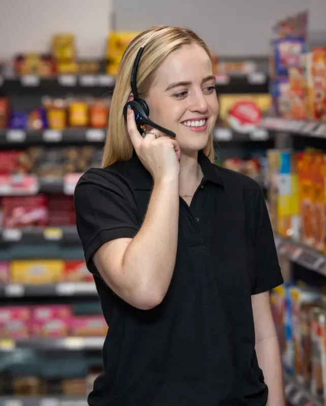 Associate pressing her Pro12 headset to listen